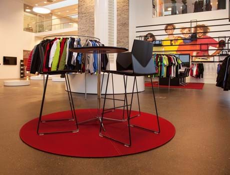 Rødt, rundt filtttæppe i showroom